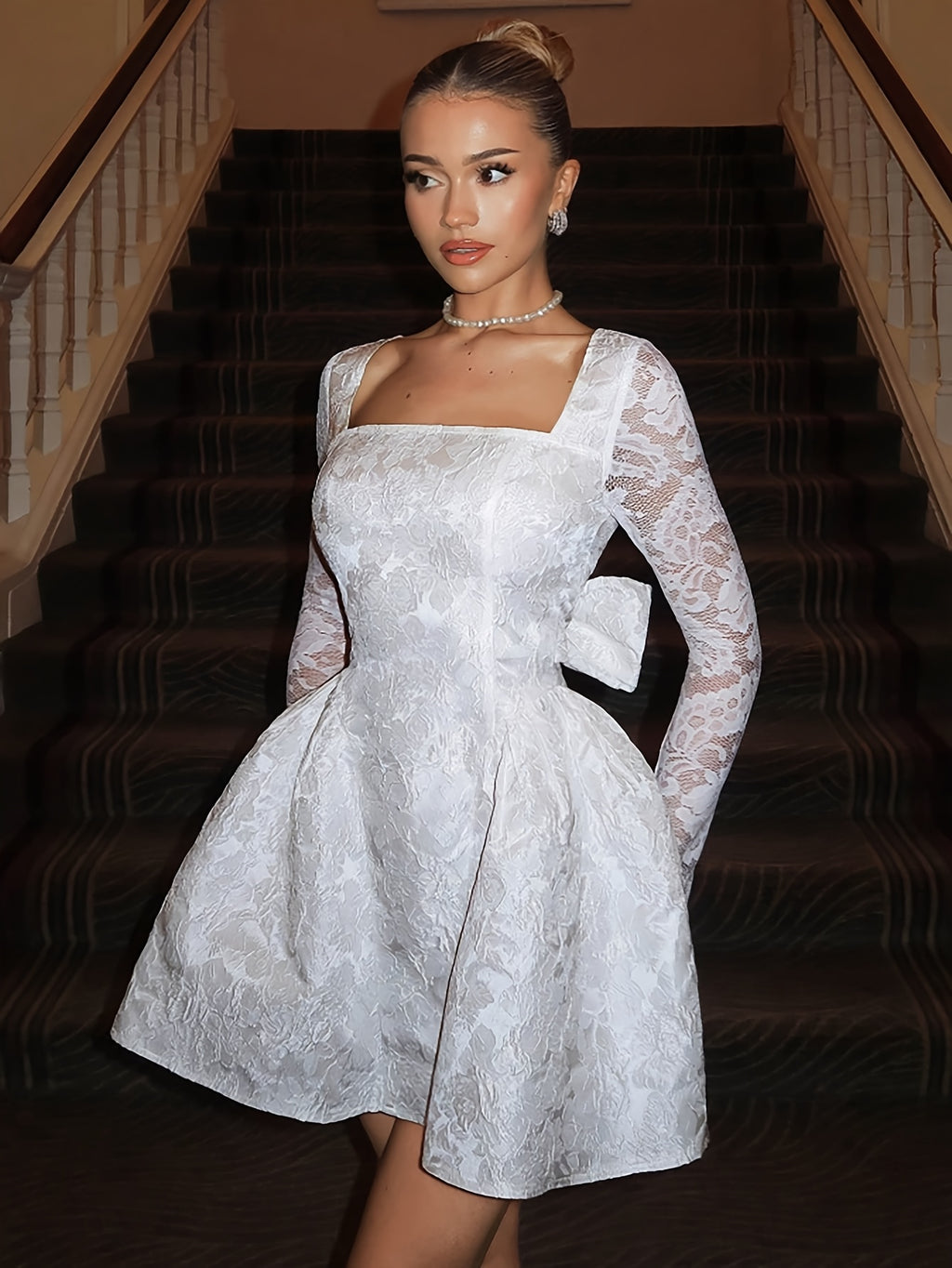 White mini dress with lace sleeves and bow for parties.